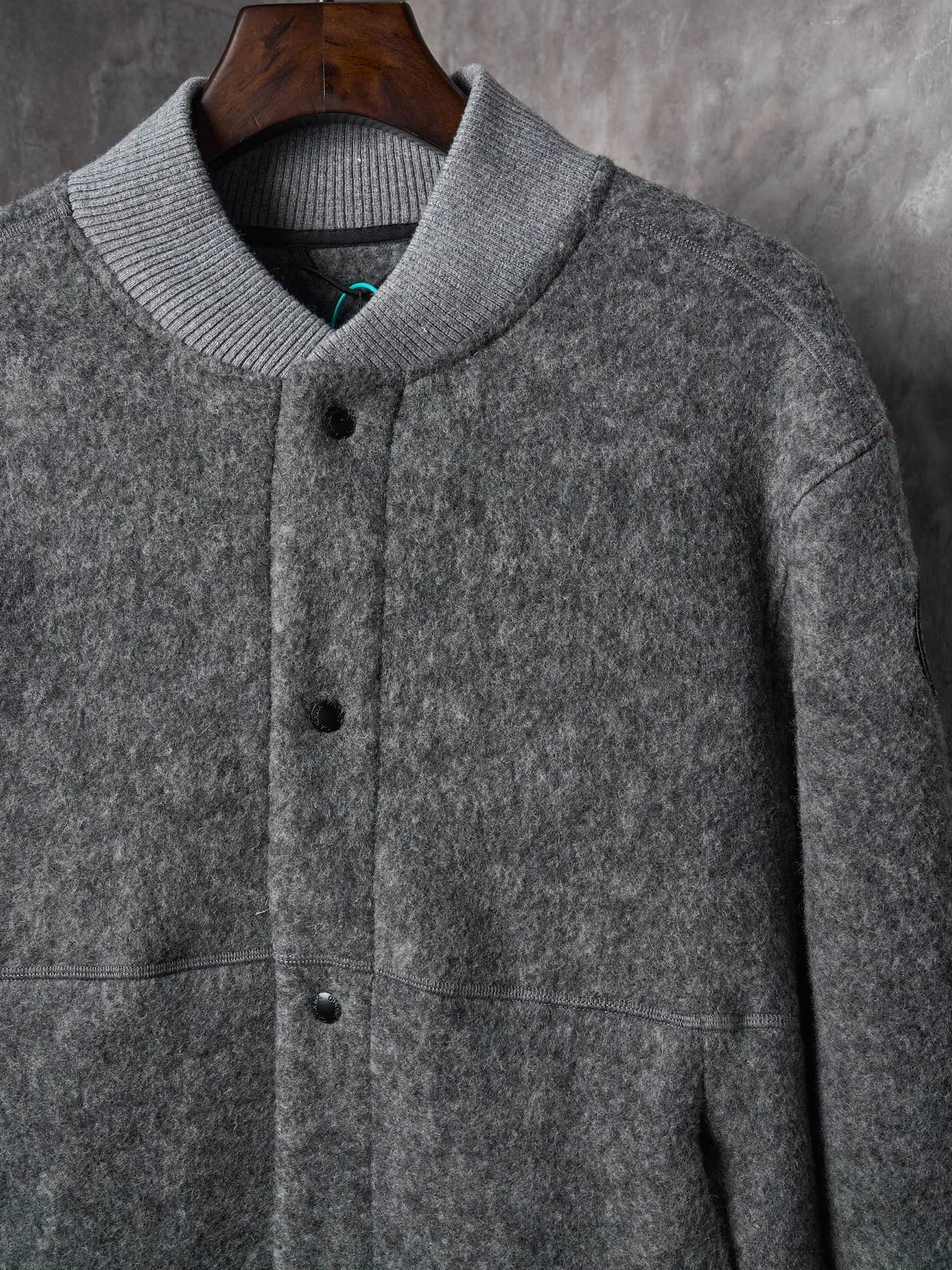 P760 Actual hanging auction] Canada Goose/Canada Goose Fleece Badge Button Cashmere Jacket [Color] Dark Gray Light Gray [Size] S M L XL Wool Blend Fabric: The main fabric of this jacket is light gray wool blend fabric to improve the wear resistance, wrinkle resistance and warmth of the fabric. Wool provides good warmth and a natural feel, while blended fibers enhance the fabric's practicality and durability.  RIBBED KNIT: The collar, cuffs and hem are ribbed knitted for added stretch and fit.  The cutting process needs to ensure that the texture and color of the fabric are evenly distributed, especially with this light gray tone, to avoid chromatic aberrations. The stretchability of wool-blend fabrics needs to be taken into consideration when cutting pieces to ensure dimensional stability of the finished garment.      Use a sewing needle and thread suitable for wool-blend fabrics to avoid damage to the fabric during sewing. The sewing stitches are even and firm to prevent thread stripping.      The temperature needs to be controlled during ironing to avoid high temperature damage to the fabric while keeping the fabric smooth and crisp.   The front and back body parts, sleeves and other main parts are stitched with flat seams to ensure a smooth silhouette.   Align the fabric texture at the splices to keep the look neat.     Details such as pockets and cuffs are designed with inset pockets to increase practicality and aesthetics.     The splicing areas are reinforced to improve durability.  The white circular armband on the left arm is an important part of the brand identity and is finely sewn to ensure it is strong and flat.